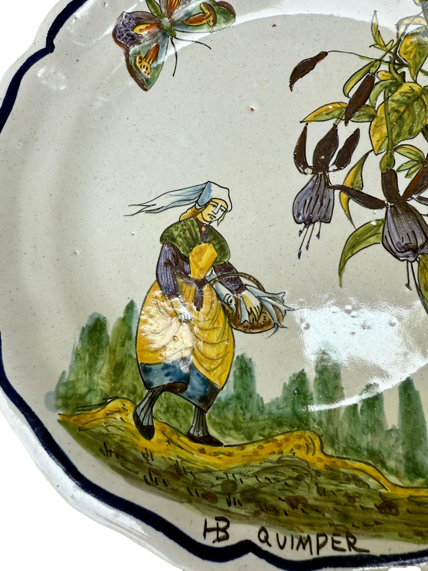 Antique HB Quimper faience plate with hand-painted Breton woman, butterfly, and flowers – 19th century French collectible
