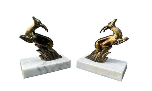 1930s French Art Deco bookends featuring elegant antelope figures on a white marble base. A beautiful vintage design that combines functionality with timeless style.