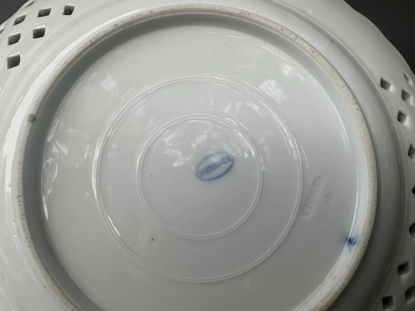 Close-up of an antique Meissen porcelain reticulated plate in the classic Blue Onion pattern. Beautifully detailed blue and white craftsmanship, perfect for collectors and decor