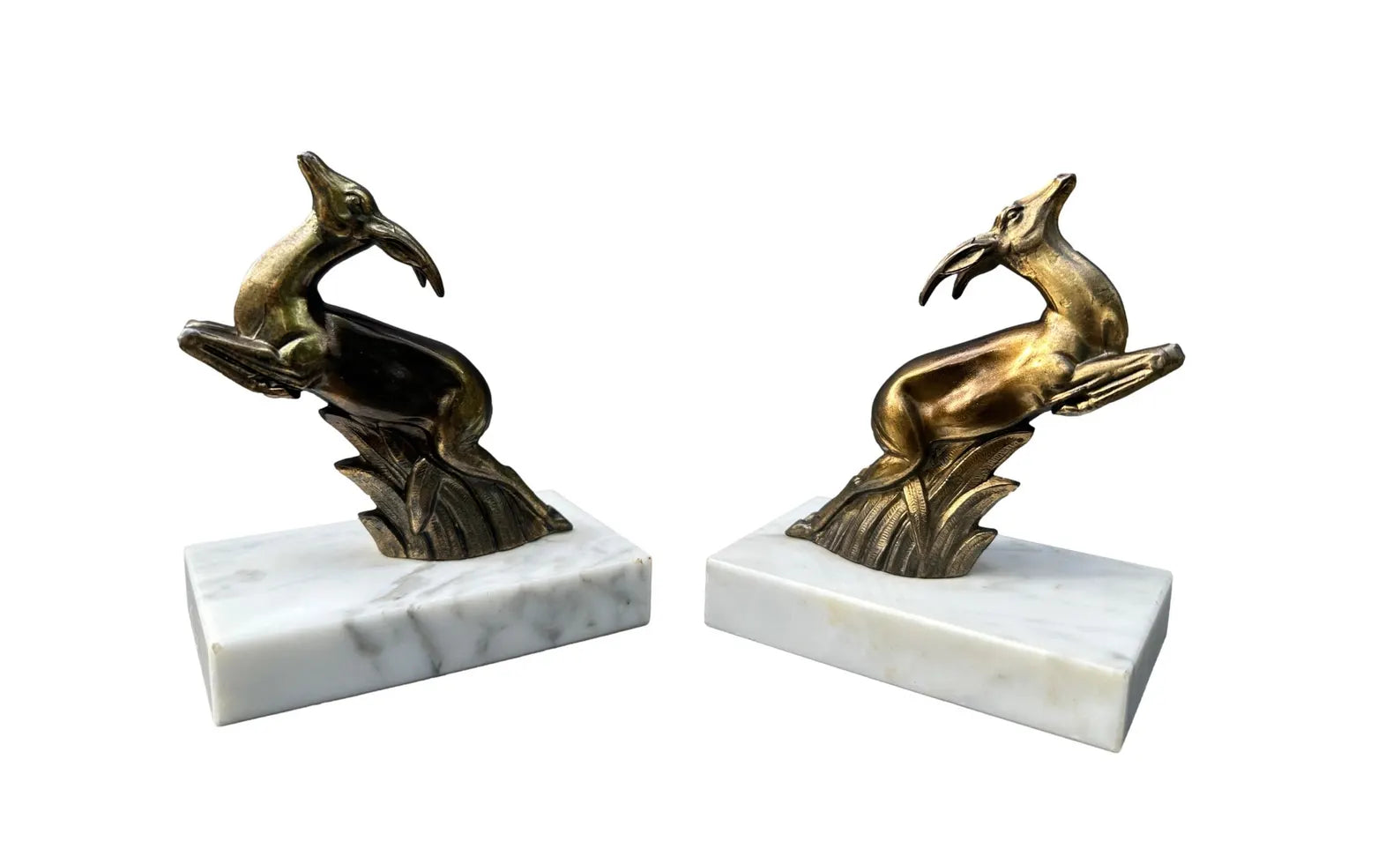 1930s French Art Deco bookends featuring elegant antelope figures on a white marble base. A beautiful vintage design that combines functionality with timeless style.