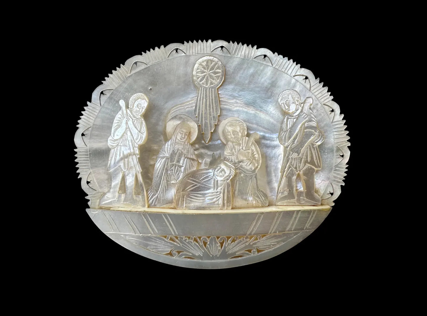 antique nativity scene intricately carved from mother of pearl, depicting the birth of Christ in Bethlehem. A beautiful and detailed representation of religious craftsmanship