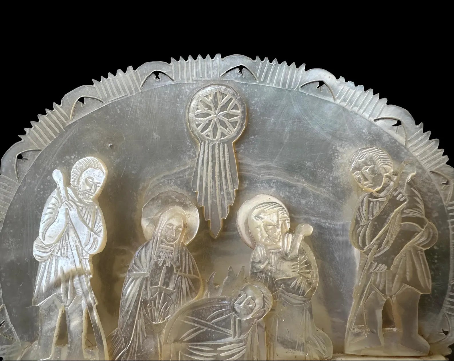 antique nativity scene intricately carved from mother of pearl, depicting the birth of Christ in Bethlehem. A beautiful and detailed representation of religious craftsmanship