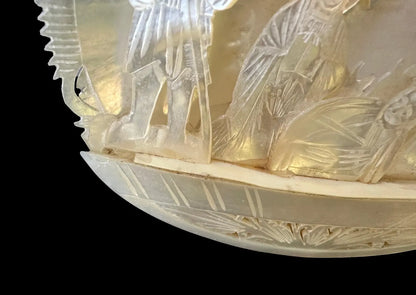 antique nativity scene intricately carved from mother of pearl, depicting the birth of Christ in Bethlehem. A beautiful and detailed representation of religious craftsmanship