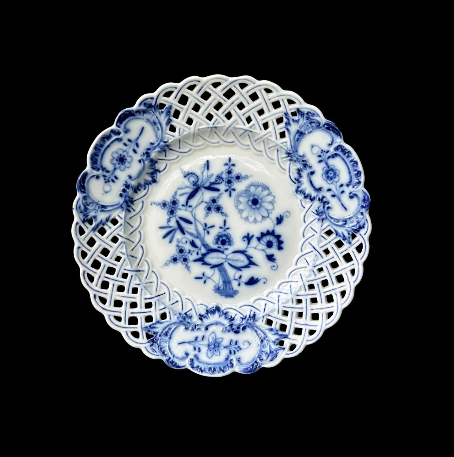 Close-up of an antique Meissen porcelain reticulated plate in the classic Blue Onion pattern. Beautifully detailed blue and white craftsmanship, perfect for collectors and decor