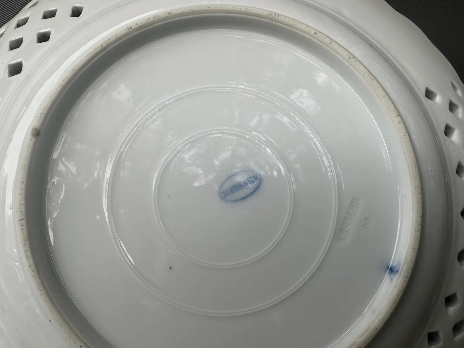 Close-up of an antique Meissen porcelain reticulated plate in the classic Blue Onion pattern. Beautifully detailed blue and white craftsmanship, perfect for collectors and decor