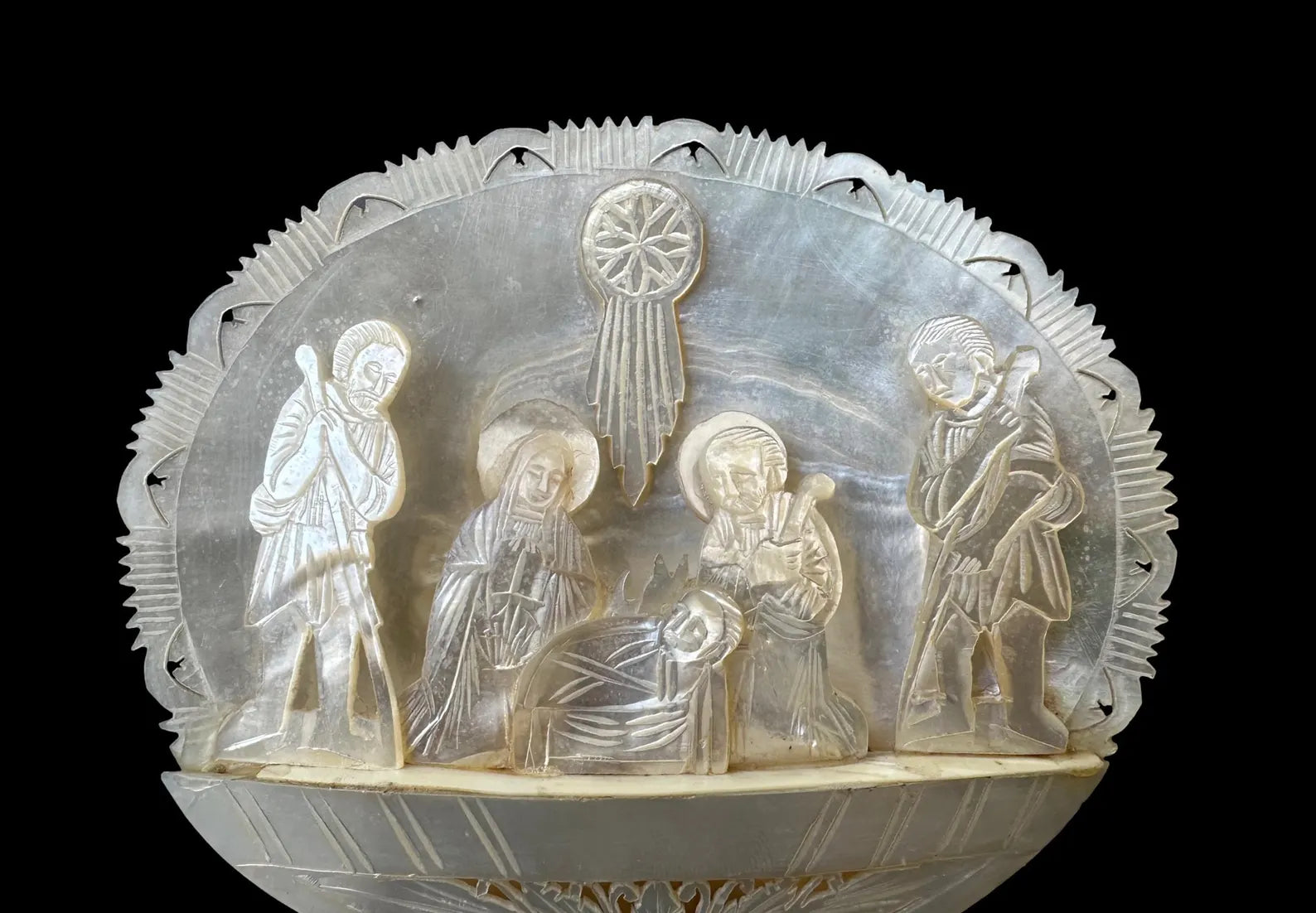 antique nativity scene intricately carved from mother of pearl, depicting the birth of Christ in Bethlehem. A beautiful and detailed representation of religious craftsmanship