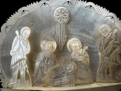 antique nativity scene intricately carved from mother of pearl, depicting the birth of Christ in Bethlehem. A beautiful and detailed representation of religious craftsmanship