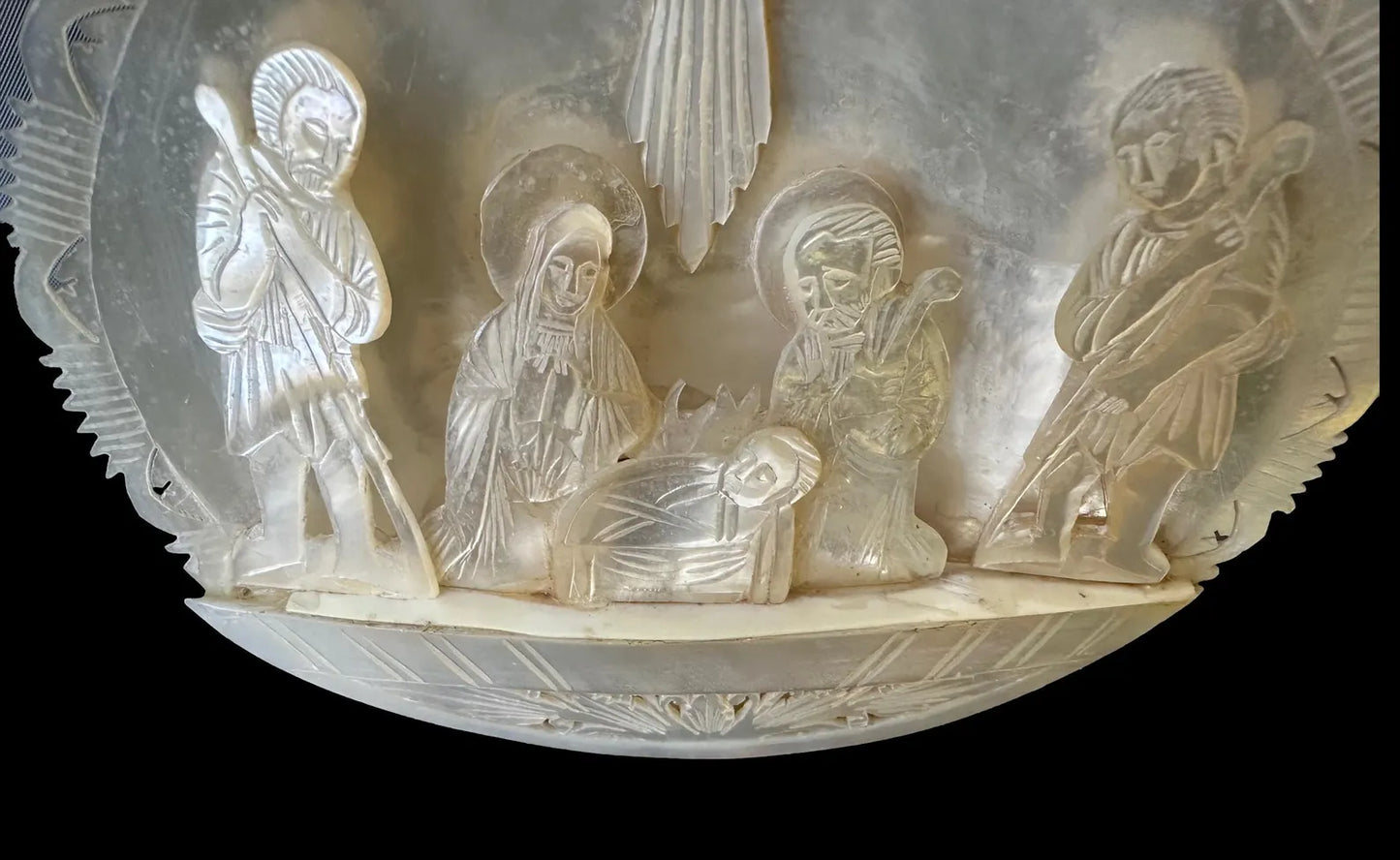 antique nativity scene intricately carved from mother of pearl, depicting the birth of Christ in Bethlehem. A beautiful and detailed representation of religious craftsmanship