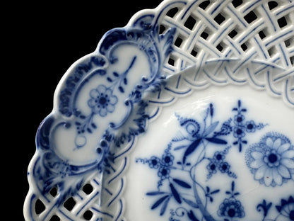 Close-up of an antique Meissen porcelain reticulated plate in the classic Blue Onion pattern. Beautifully detailed blue and white craftsmanship, perfect for collectors and decor