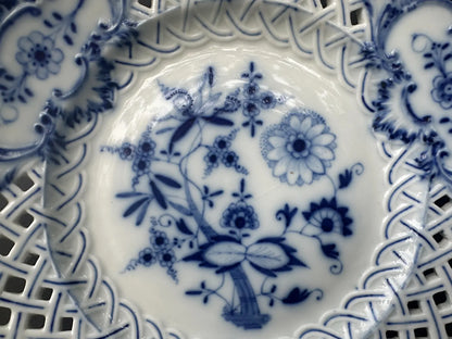 Close-up of an antique Meissen porcelain reticulated plate in the classic Blue Onion pattern. Beautifully detailed blue and white craftsmanship, perfect for collectors and decor