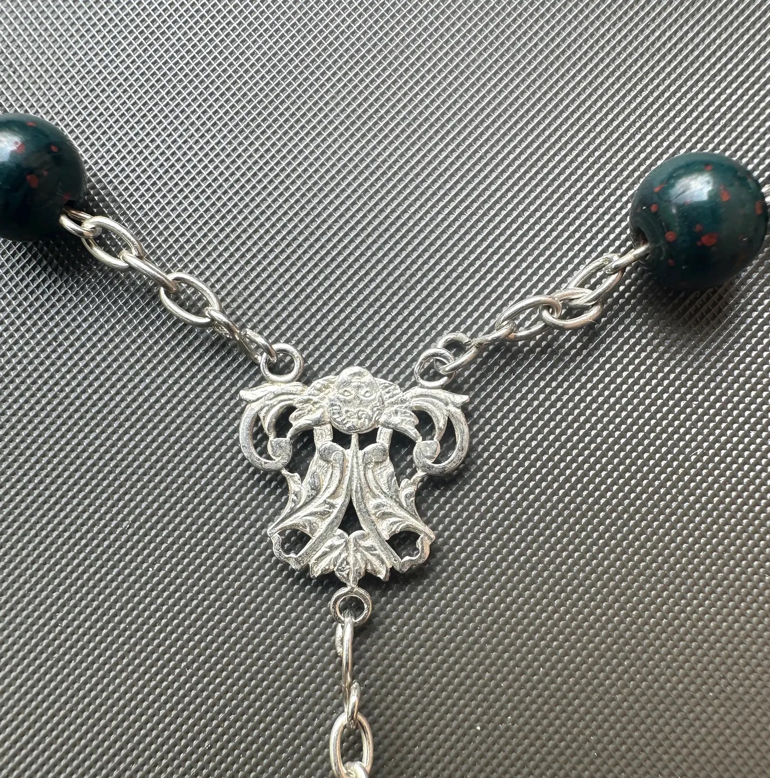 Antique bloodstone rosary with sterling silver crucifix on white background