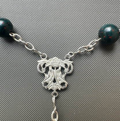 Antique bloodstone rosary with sterling silver crucifix on white background